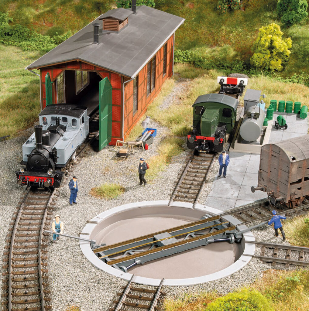 Modell eines Lokschuppen mit kleiner Drehscheibe und zwei Dampfloks